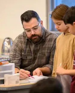 Teacher helping students at table