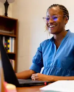 Teacher smiling at laptop