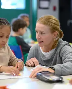 Teacher helping student at a table