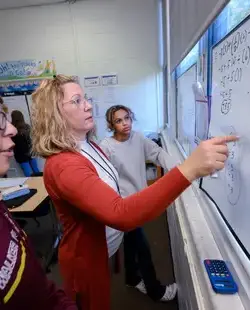 Math teacher pointing at whiteboard